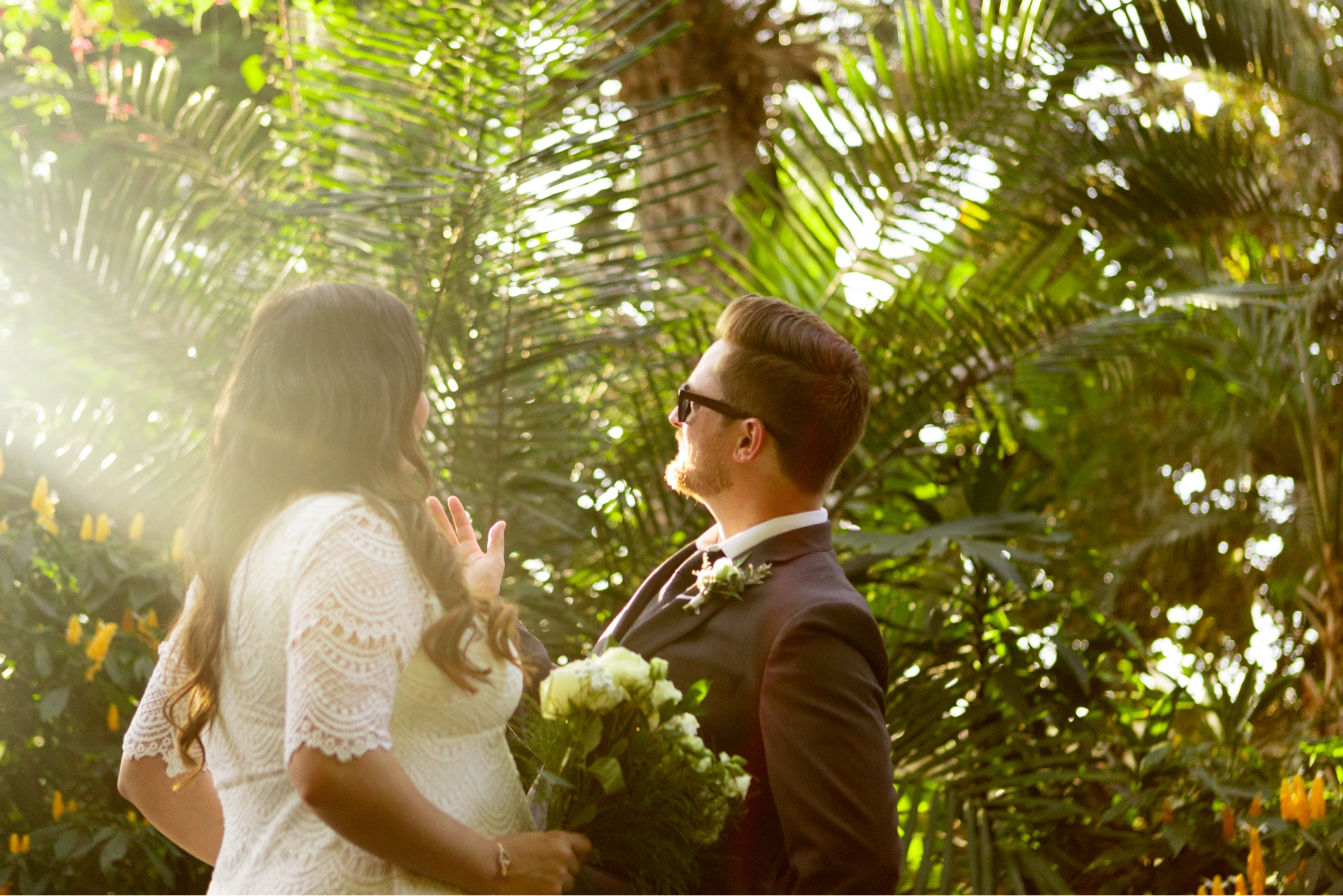 Bride and groom facing each other in warm tropical backlight during a wedding portrait
